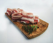 Load image into Gallery viewer, Fresh pre cooked bacon on a cutting board